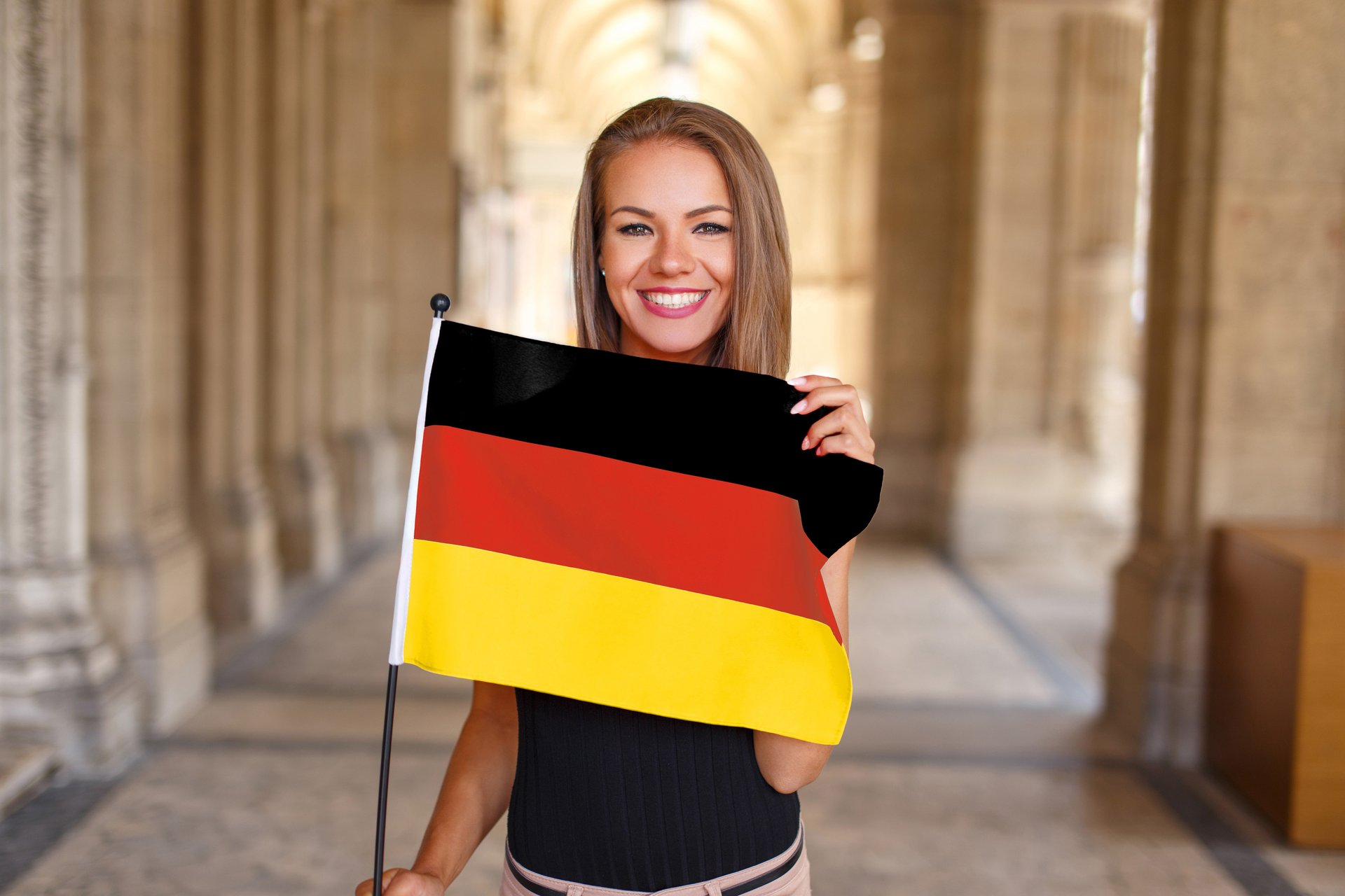eine junge Frau hält eine Deutschlandflagge in den Händen