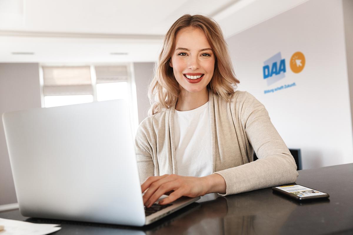Eine blonde Frau nimmt am Laptop an einer Online-Weiterbildung teil