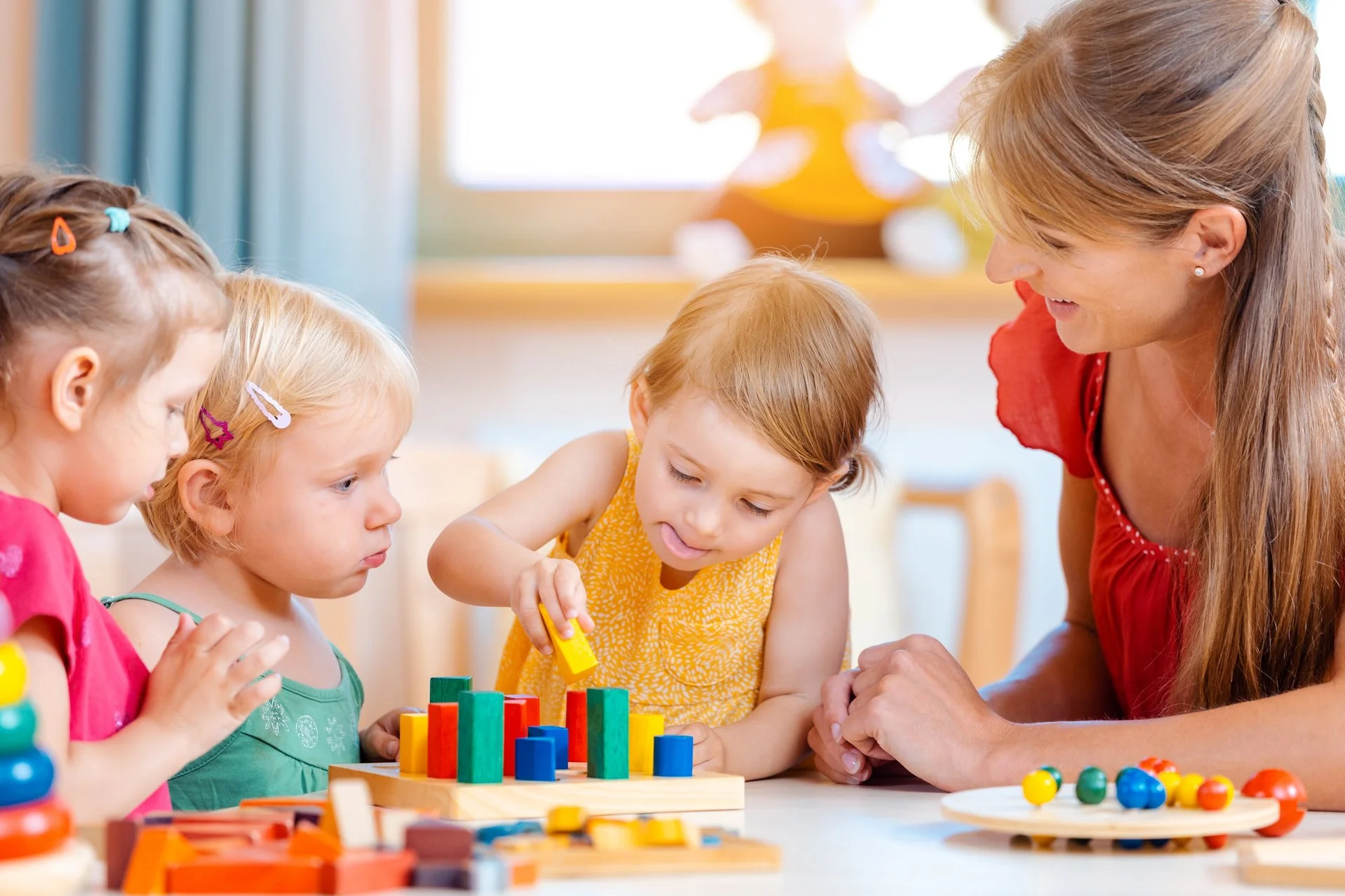 eine pädagogische Mitarbeiterin mit Kindern in einer Kita