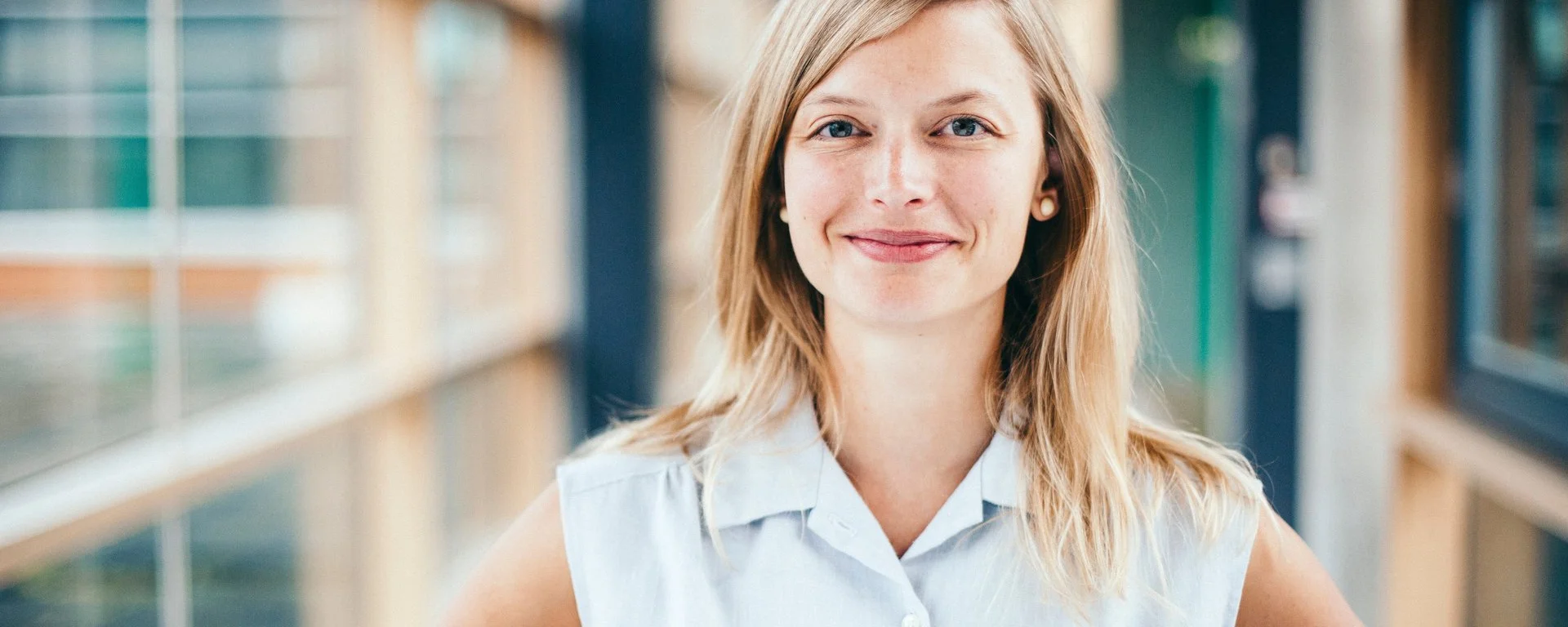 eine blonde Frau lächelt freundlich