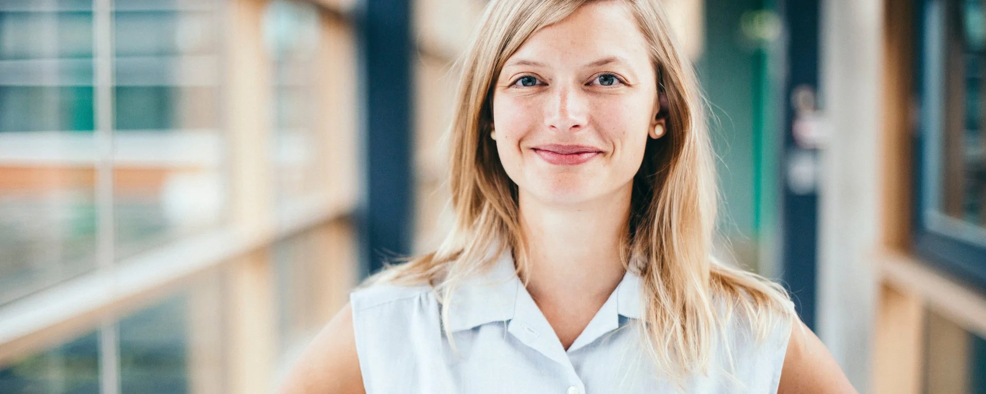 eine blonde Frau lächelt freundlich