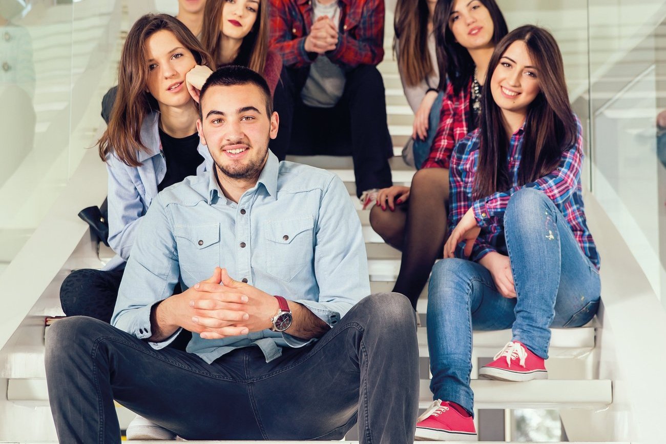 eine Gruppe Jugendlicher sitzt auf einer Treppe