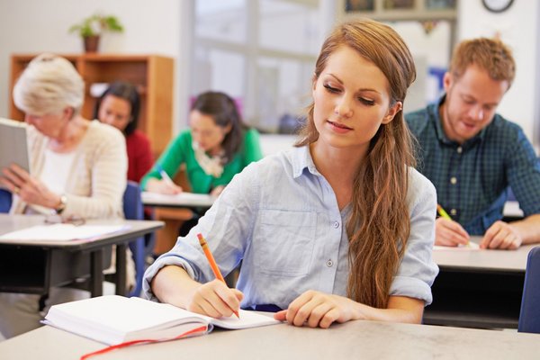 mehrere Lernende machen sich in einem Schulungsraum Notizen