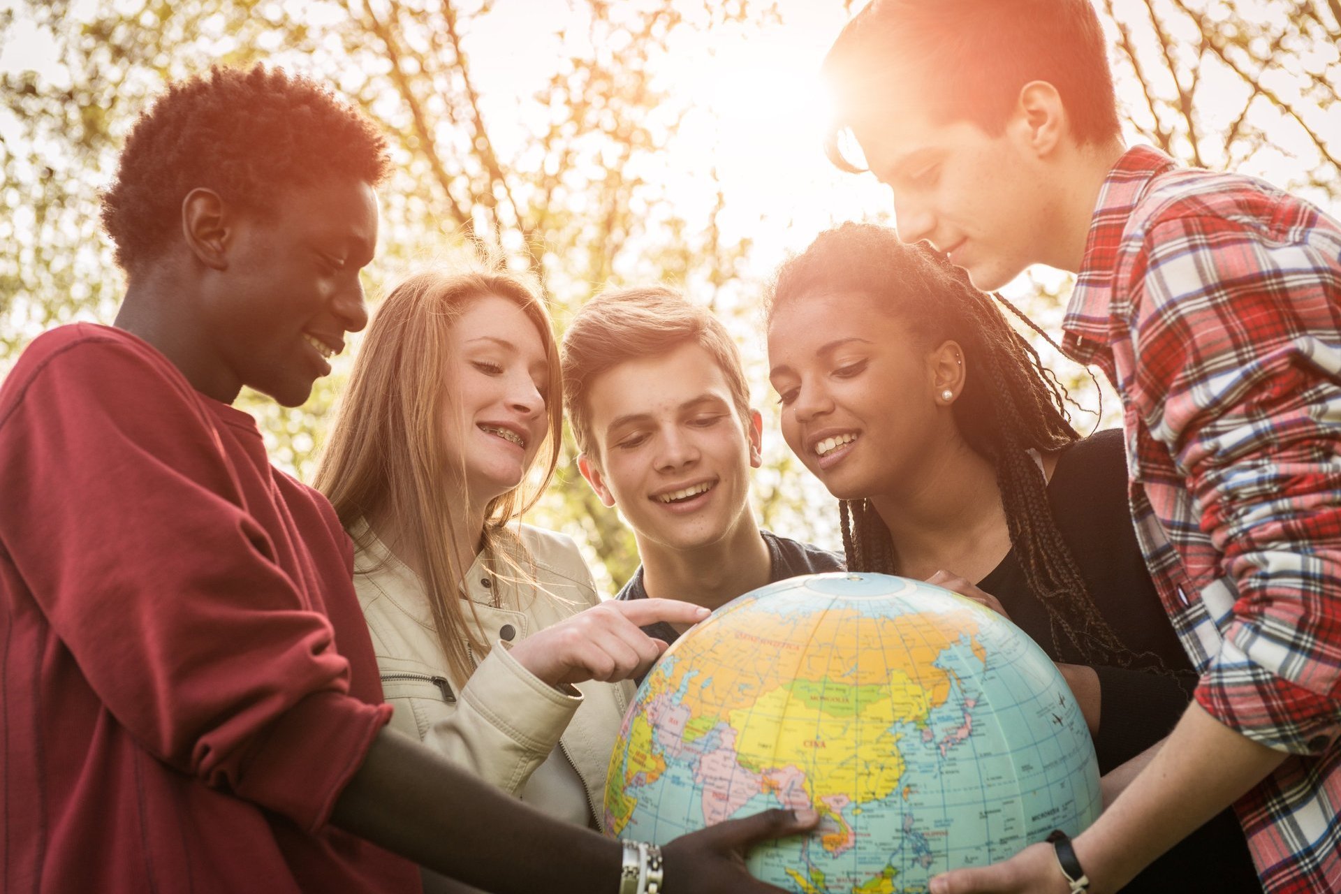 5 junge Menschen halten einen Globus